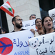 Demonstrators carry banners and a Lebanese flag as they protest outside the Touch telecommunications building in Beirut, Lebanon November 5, 2019.